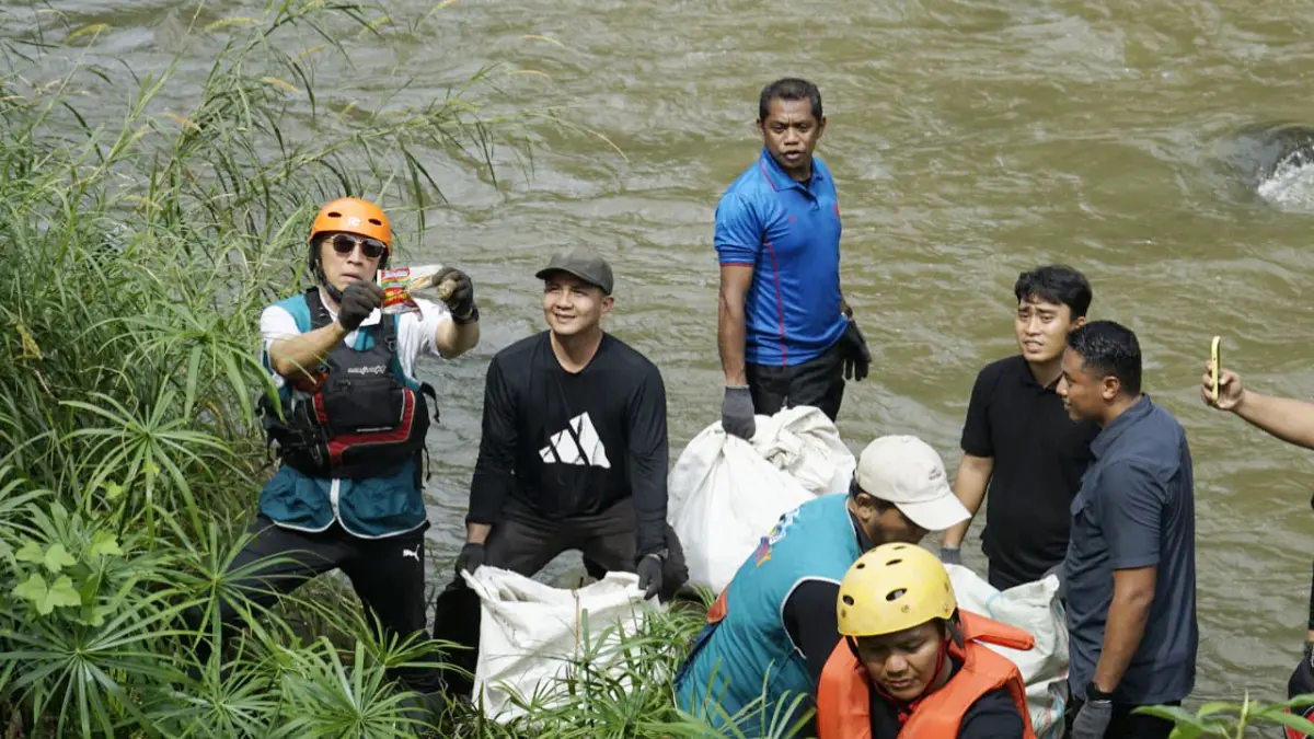 Wali Kota Bogor Dedie A Rachim bersama peserta kegiatan mengangkat sampah saat aksi bersih-bersih Sungai Ciliwung di kawasan Kebun Raya Bogor, Sabtu, 25 April 2026. (Azis/Radar Bogor)