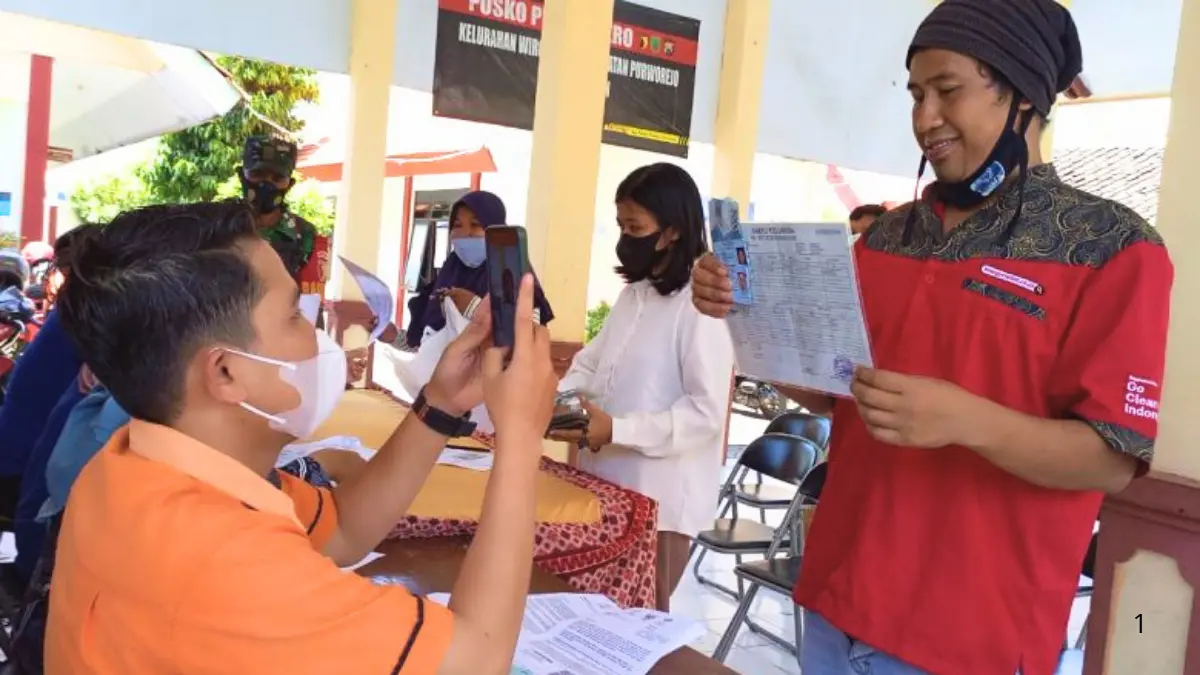 Pengambilan foto sebagai bukti terima bansos. (Foto: pasuruankota.go.id)