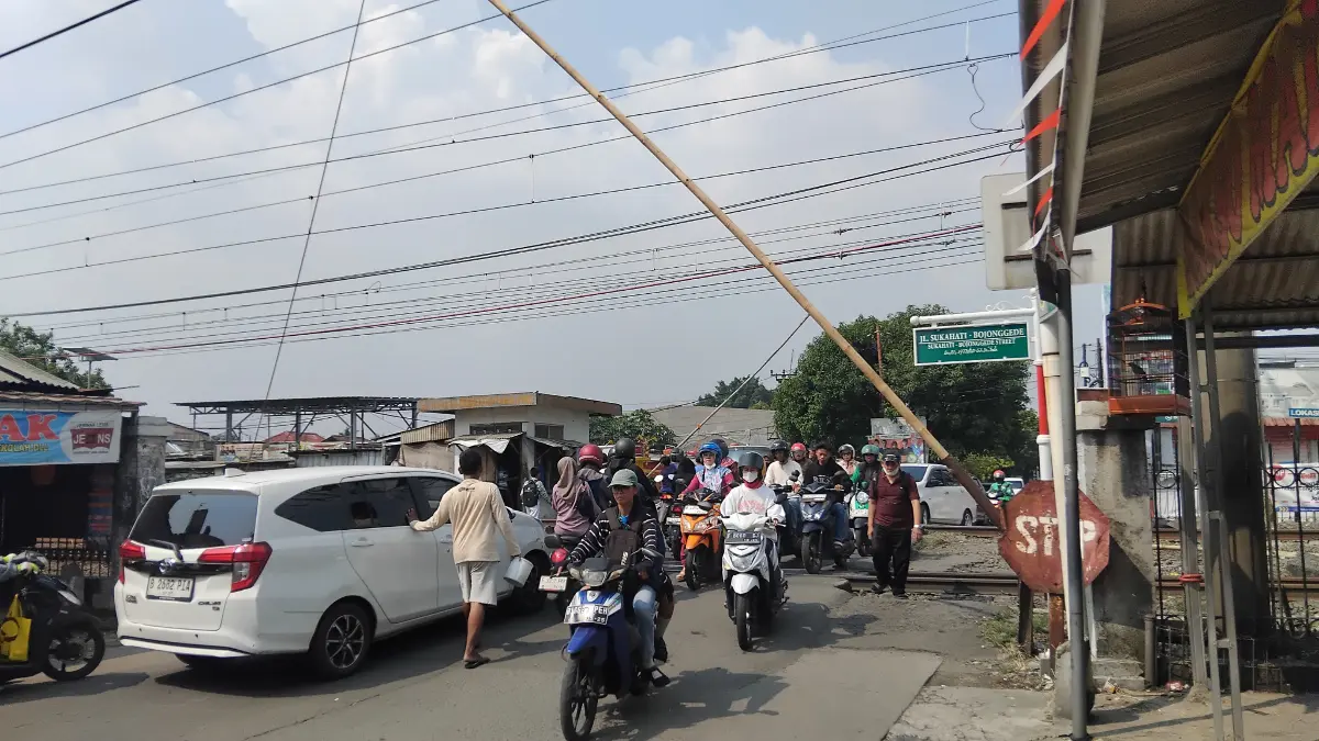 Masyarakat saat melintas di perlintasan kereta api di Gaperi, Bojonggede, Bogor. Foto:Billy/Radar Bogor.