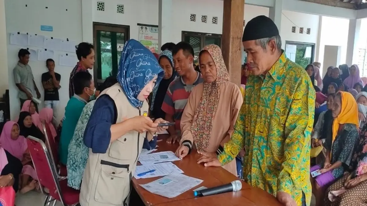 Petugas mendistribusikan dana bansos. (Foto: kuniran-bjn.desa.id)