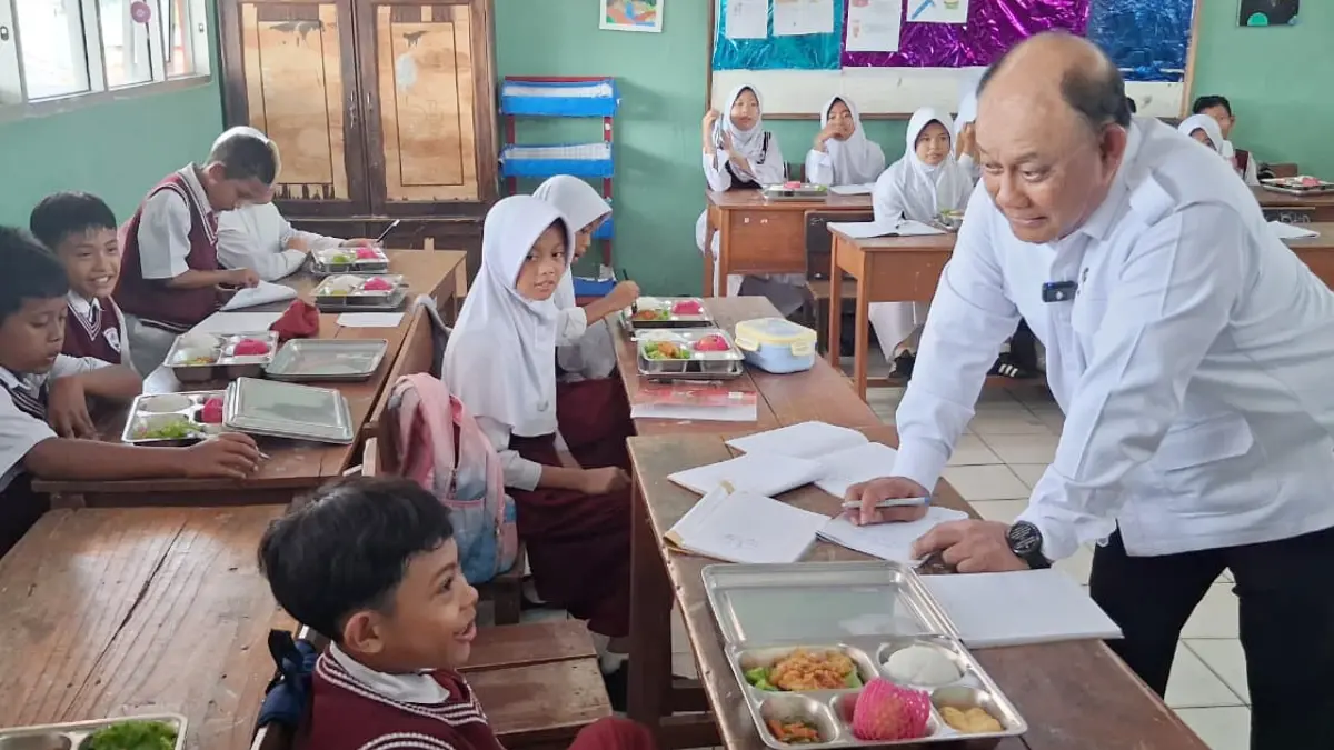 Kepala BGN RI Dadan Hindayana saat menandatangani selebar kertas dari siswa di SDN Citaringgul 02, Kecamatan Babakan Madang, Kabupaten Bogor, Senin, 11 Mei 2026. (Muhammad Ali/Radar Bogor)