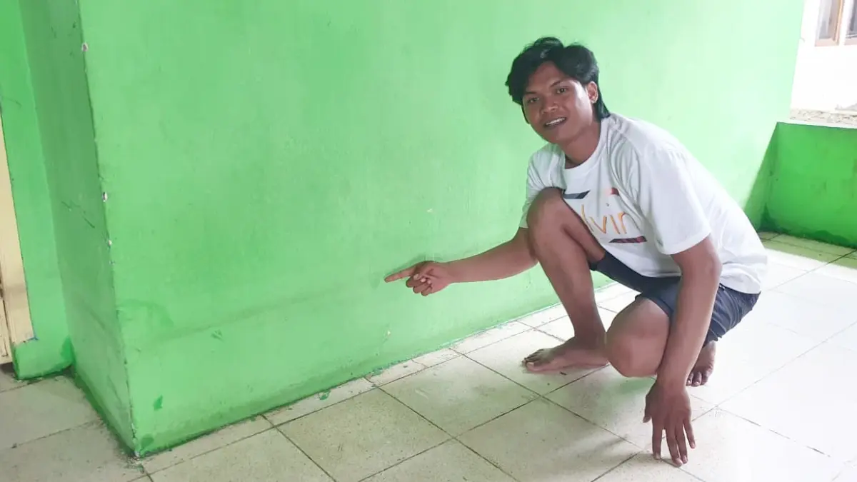Bintang warga sekitar Jalan Raya Sukahati, Cibinong, Kabupaten Bogor saat menunjukan bekas banjir di rumahnya. (Billy/Radar Bogor)