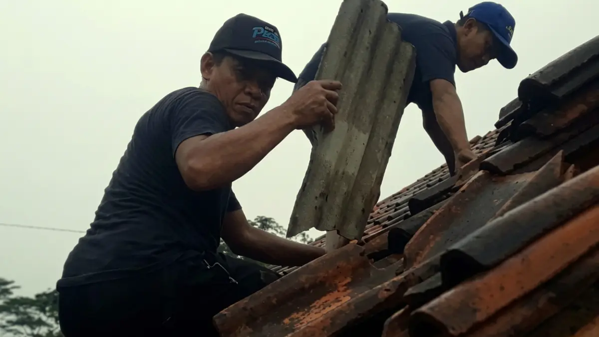 Warga Kampung Parakanomas, Desa Tamansari, Rumpin Bogor memperbaiki sendiri atap yang rusak. (Nasir/ Radar Bogor)