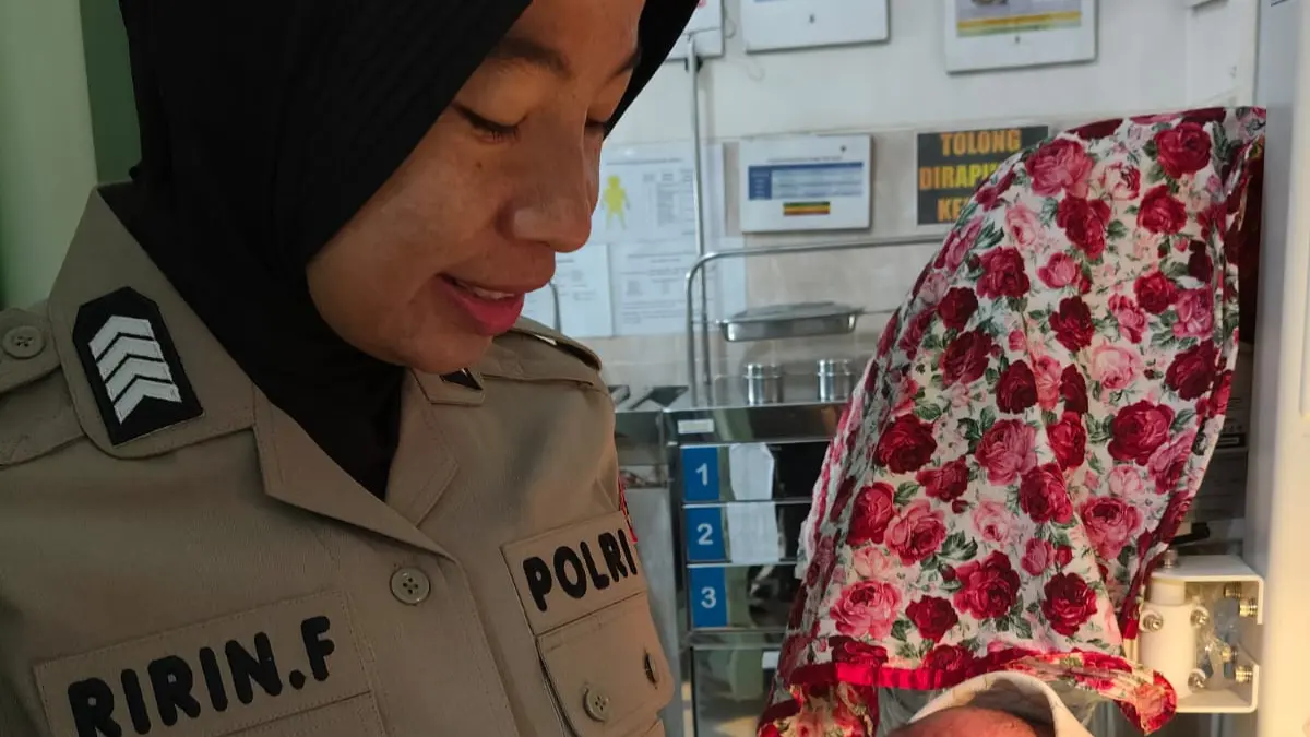 Polwan anggota Polsek Parung menggendong bayi yang ditemukan, Rabu 3 Juni 2026.  (Nasir/ Radar Bogor)