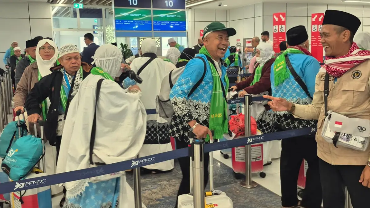 Ketua Kloter JKS 03, Ade Irawan (kanan) mendampingi para jamaah haji asal Bogor yang menjalani pemeriksaan barang bawaan.