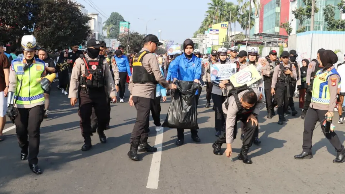 Kapolres Metro Depok Kombes Pol Abdul Waras memungut sampah yang berserakan di Jalan Margonda Depok saat CFD Minggu, 7 Juni 2026 pagi. (Dok. Humas Polres Metro Depok)