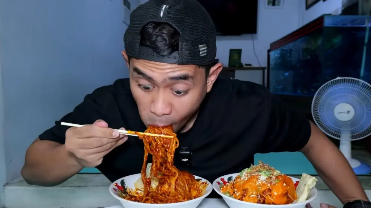 Tanboy Kun saat mencicipi mie jebew level lima di Garut, Jawa Barat. (Foto: Youtube Tanboy Kun)