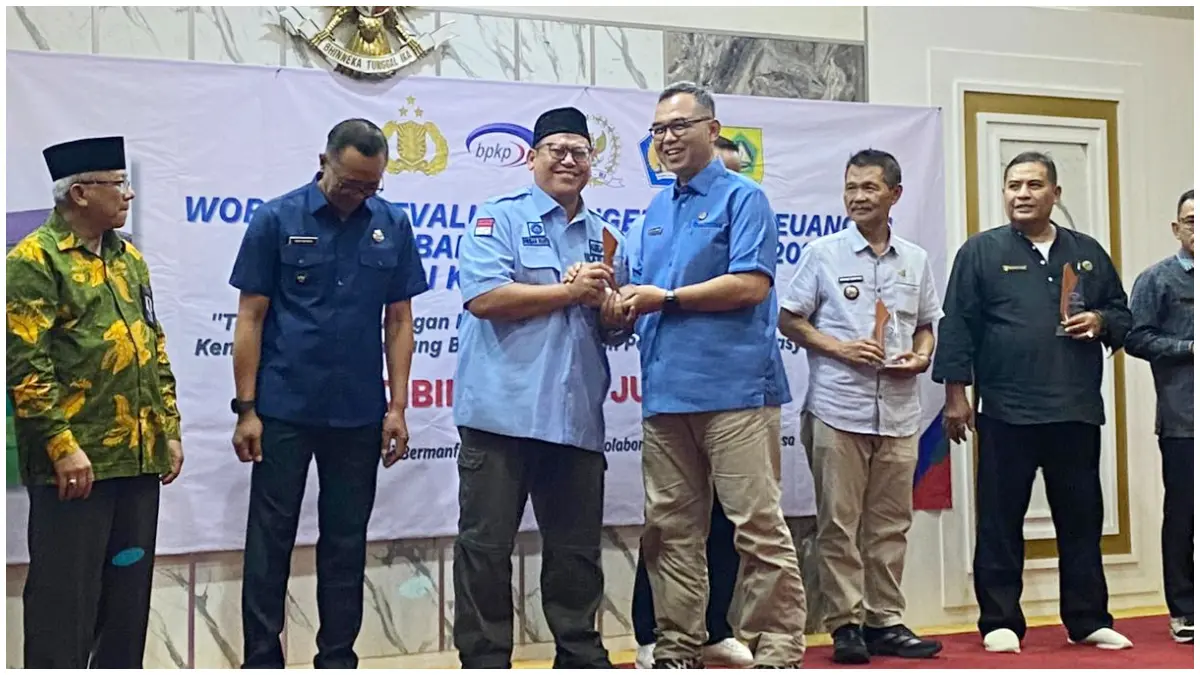 Kepala Desa Bojong Kulur, Firman Riansyah saat menerima penghargaan dari Sekretaris Daerah Kabupaten Bogor, Ajat Rochmat Jatnika di Cibinong, Kabupaten Bogor. (Foto: Muhammad Ali/Radar Bogor)