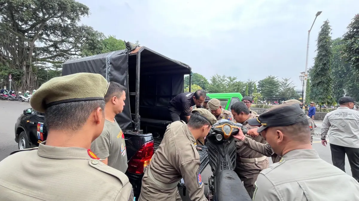 Petugas Satpol PP saat mengamankan sepeda motor milik PKL di Jalan Dewi Sartika Kota Bogor. (Foto : Dzikry/Radar Bogor)