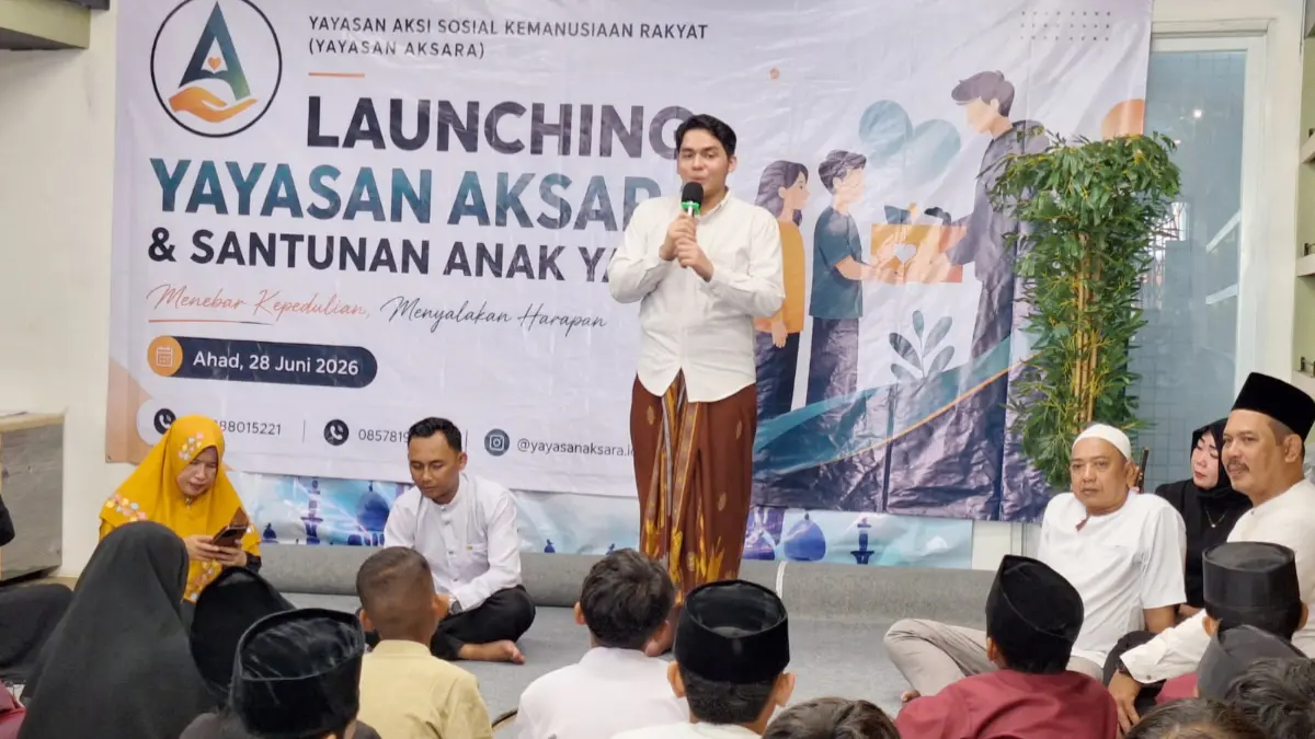 Ketua Yayasan AKSARA, Ibrahim Askar (tengah), secara simbolis menyerahkan santunan kepada salah satu anak yatim dalam acara launching Yayasan AKSARA di SMK UMMI Kota Bogor, Jalan Pekojan, Empang, Bogor Selatan, Minggu 28 H Juni 2026. (Dede/Radar Bogor)