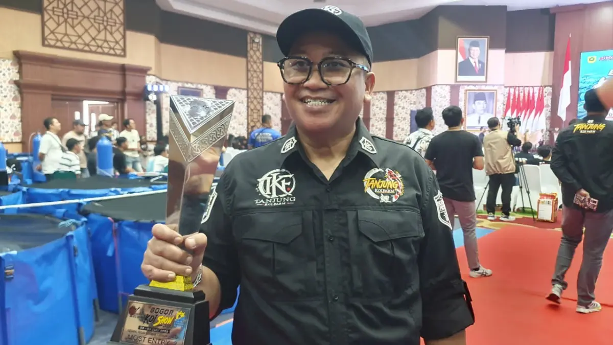 Owner Tanjung Koi Farm saat menerima simbolis piala kejuaraan. Foto:Billy/Radar Bogor.