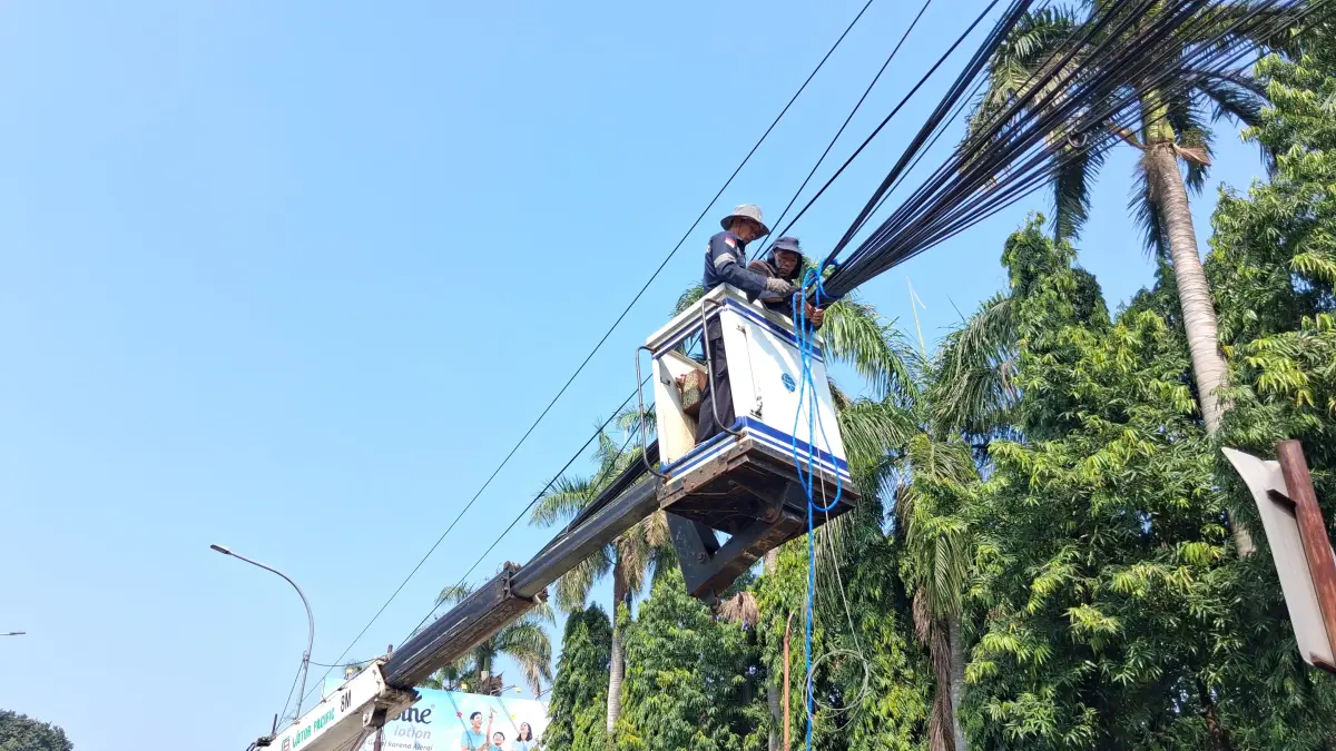 Petugas lapangan saat menrapihkan kabel udara yang semrawut di Jalan Raya Bogor-Jakarta, Sukaraja Rabu 8 Juli 2026. (Foto: Muhammad Ali/Radar Bogor)