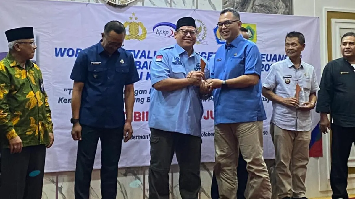 Kepala Desa Bojongkulur Firman Riansyah saat menerima penghargaan dari Sekretaris Daerah Kabupaten Bogor, Ajat Rochmat Jatnika. (Muhammad Ali/Radar Bogor)