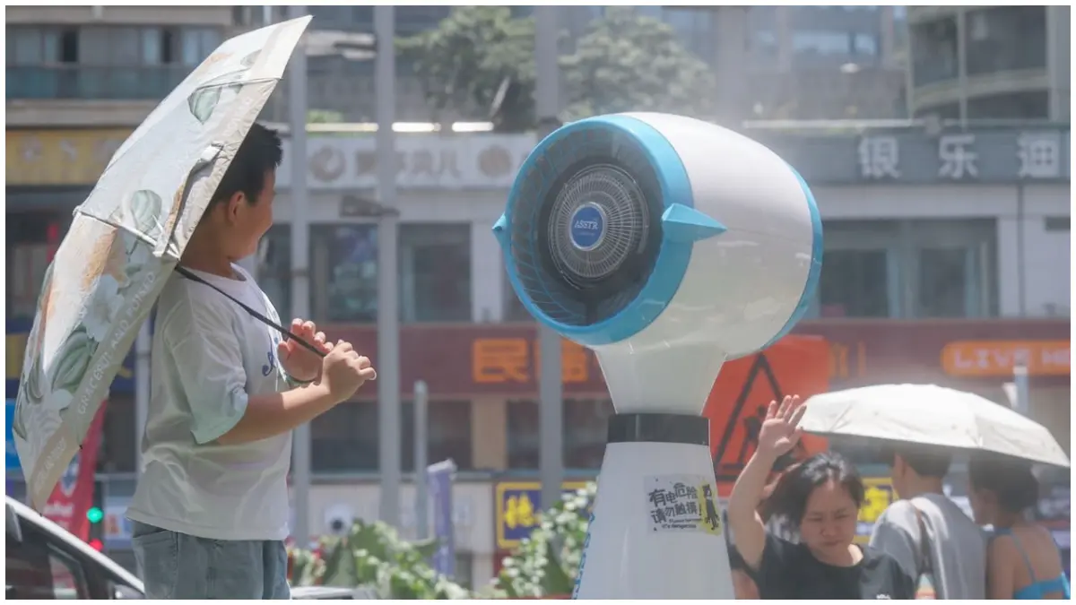 Warga memanfaatkan kipas raksasa untuk mendinginkan diri saat cuaca panas melanda di China. (Foto: Xinhua News Agency via Getty Images)&nbsp;