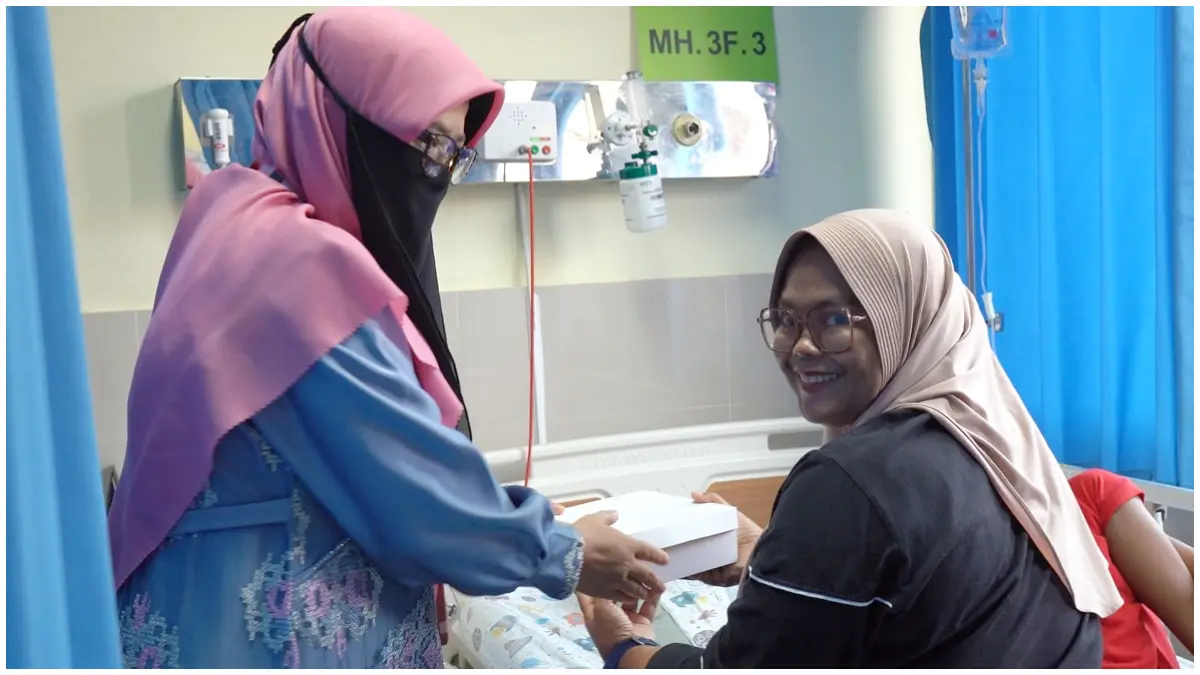 Salah seorang anggota keluarga pasien saat menerima makanan gratis dari RSUD R Moh Noh Nur.