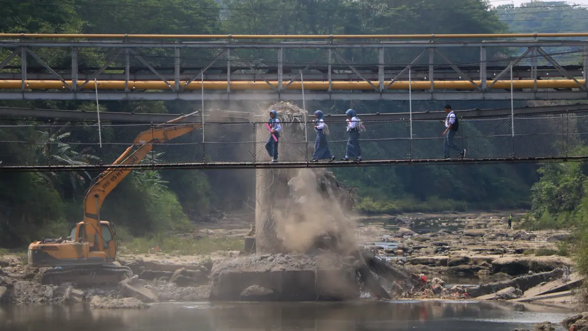 Warga memanfaatkan jembatan gantung di Desa Kembang Kuning, Klapanunggal, Kabupaten Bogor imbas penutupan Jembatan Kedep atau Jembatan Wika yang menjadi penghubung Kecamatan Gunung Putri dan Klapanunggal. (Hendi Novian/Radar Bogor)