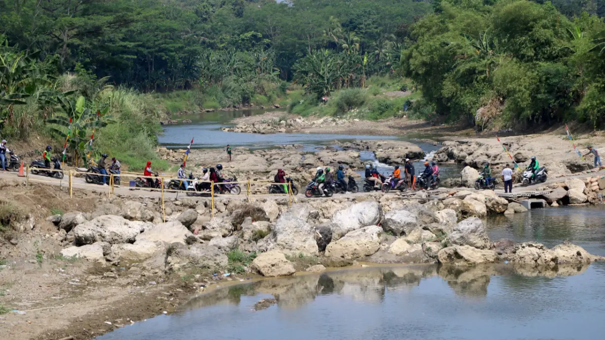 Pengendara melintasi jalan alternatif di Desa Kembang Kuning, Klapanunggal, Kabupaten Bogor, Jawa Barat. Jalan pintas digunakan warga selama perbaikan jembatan penghubung ruas jalan Gunung Putri-Klapanunggal yang ditutup. (Hendi Novian/ Radar Bogor)