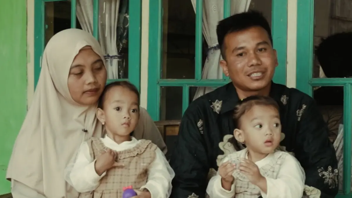 Guru honorer, Asep Anwar Maulana bersama istri menggendong kedua anaknya. (Humas Jabar)