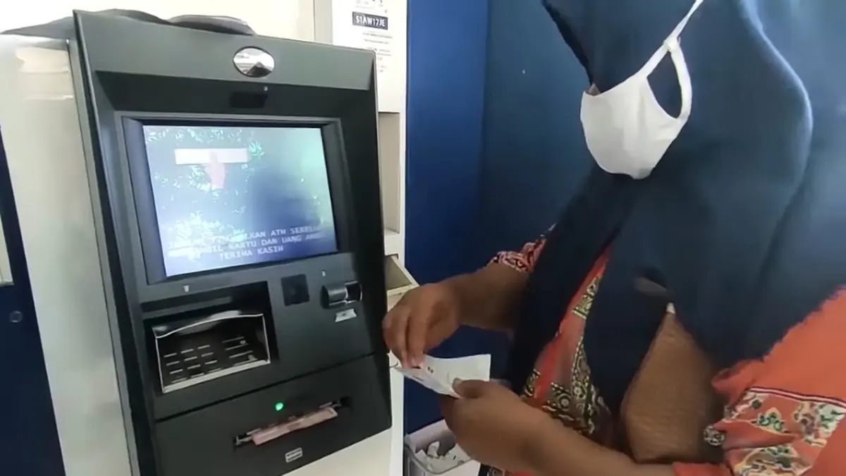 Ilustrasi pencairan bansos BPNT lewat mesin ATM Bank Himbara. (YouTube Info Bansos)