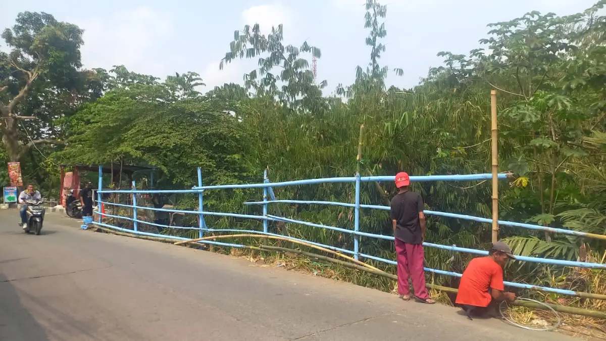 Proses pemasangan pagar bambu di Jalan Raya Cilebut Kota Bogor. (Foto : Lurah for Radar Bogor)