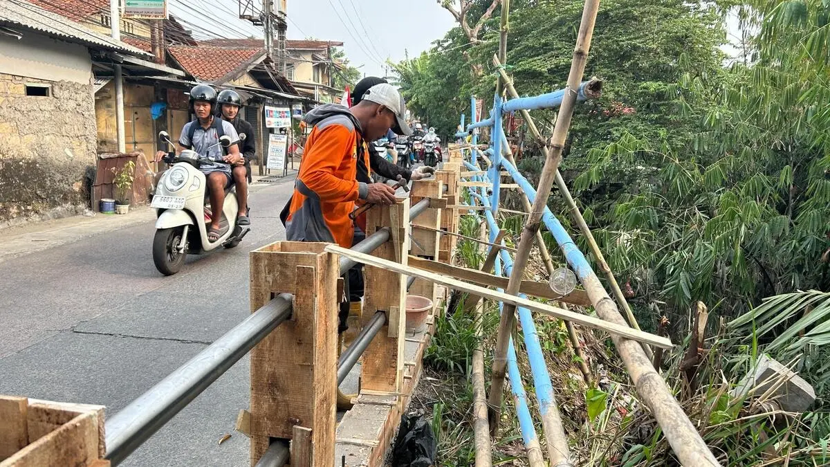 Petugas yang tengah memasang pagar railing di Jalan Raya Cilebut (Fauzan/Radar Bogor)