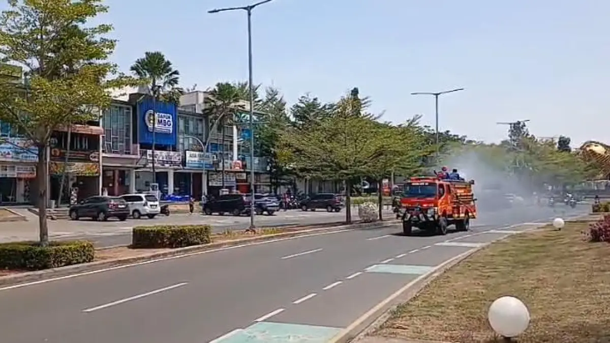 Petugas Disdamkarmat Kabupaten Bogor saat menyemprot air ke jalan raya guna mencegah pencemaran abu vulkanik. (Foto : Tangkapan layar video)