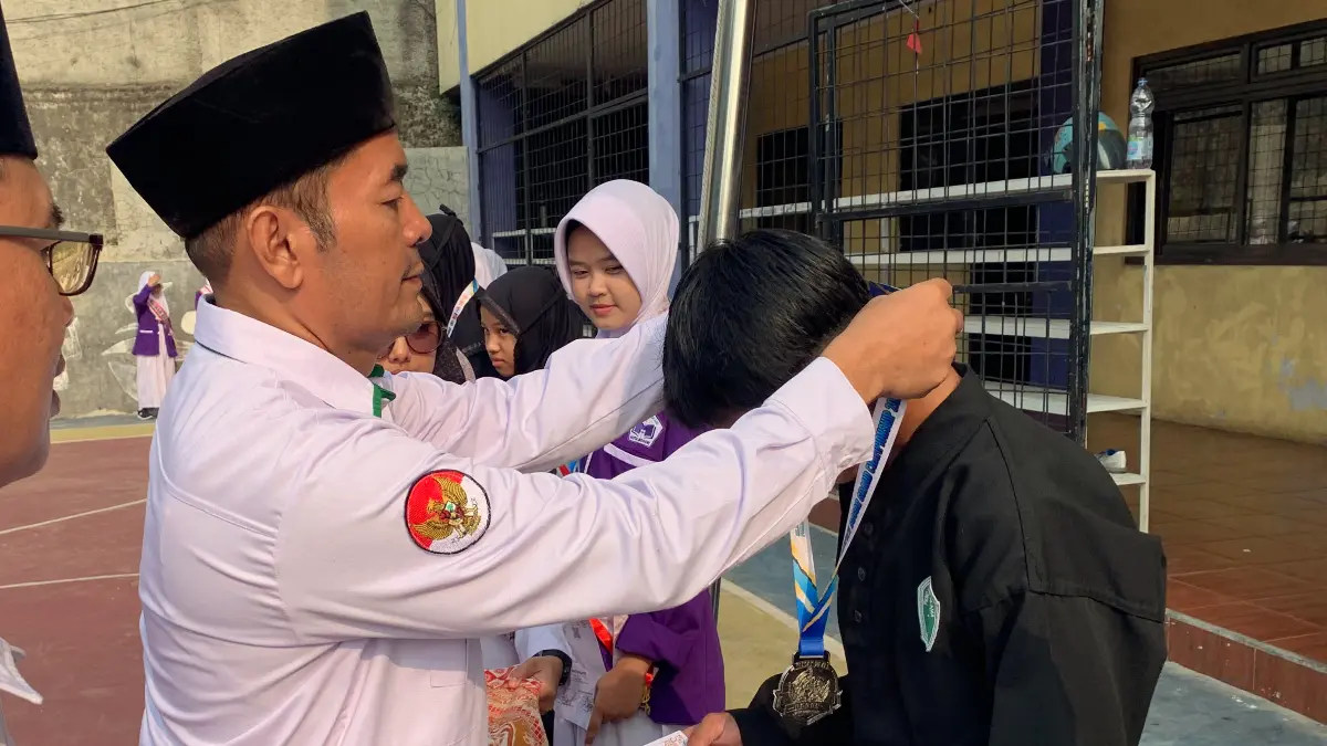 Pimpinan Ponpes Nurani Kota Bogor, Ade Sarmili menyematkan medali.