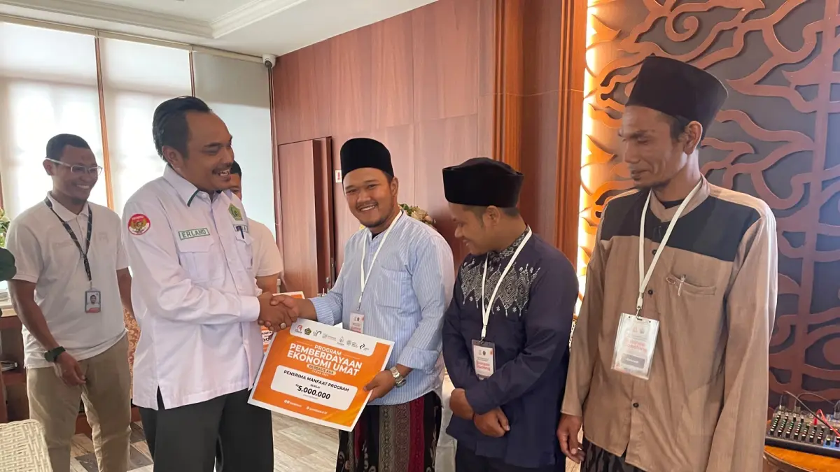 Kepala KUA Kecamatan Cijeruk, H. Erland D Ahmad, S.HI secara simbolis menyerahkan bantuan Program PEU kepada penerima manfaat.