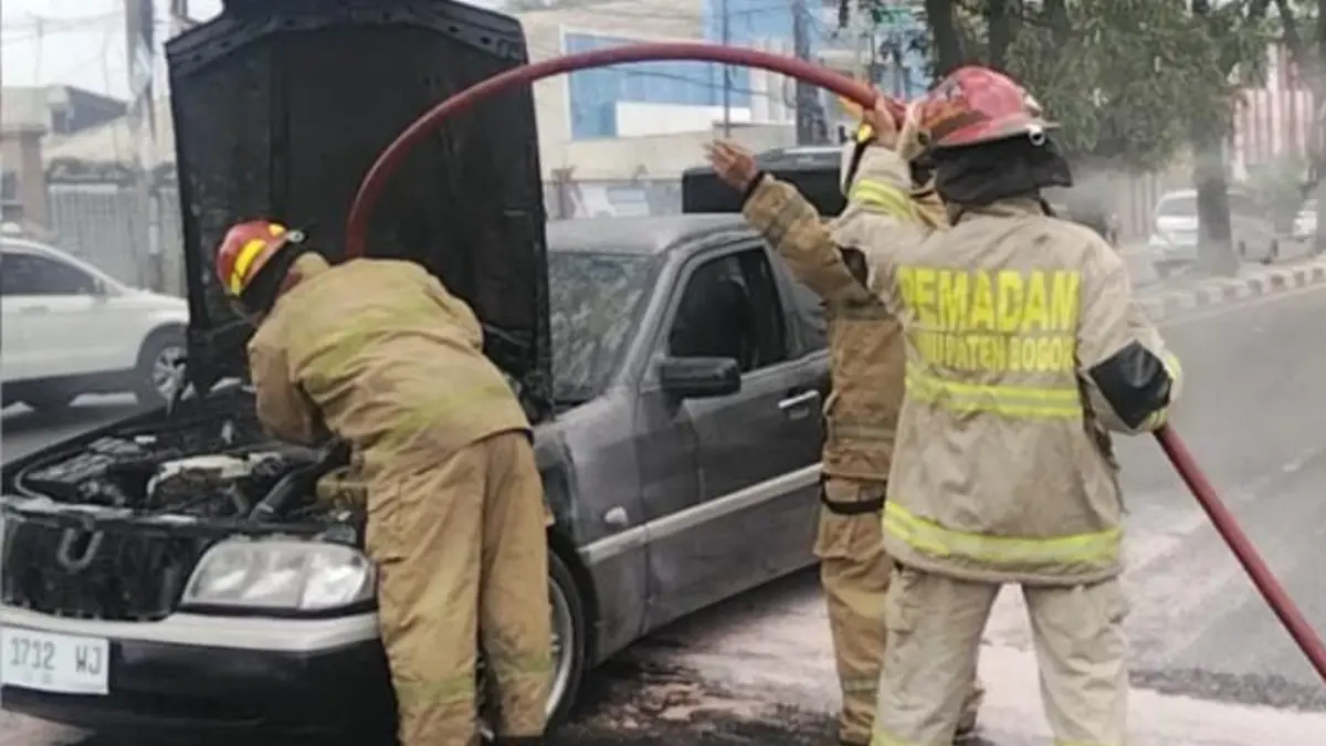 Petugas Damkar saat melakukan pendinginan mobil yang terbakar di Jalan Transyogi, Cileungsi, Kabupaten Bogor, Minggu, 27 September 2026. (Dok. Damkar Kabupaten Bogor)