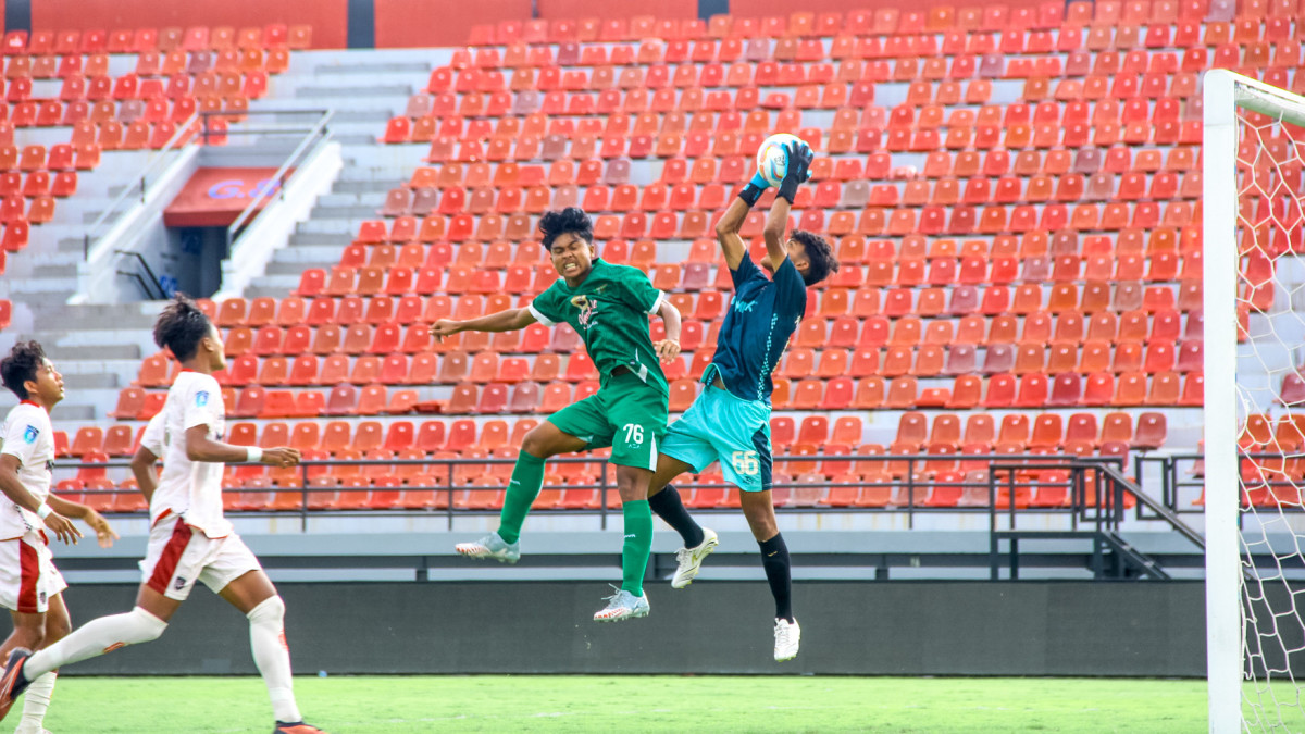 Pemain Persebaya U-16 Razsa Ahmad Dani berduel udara dengan penjaga gawang Bali United U-16 . (Persebaya)/Sumber: persebaya.id