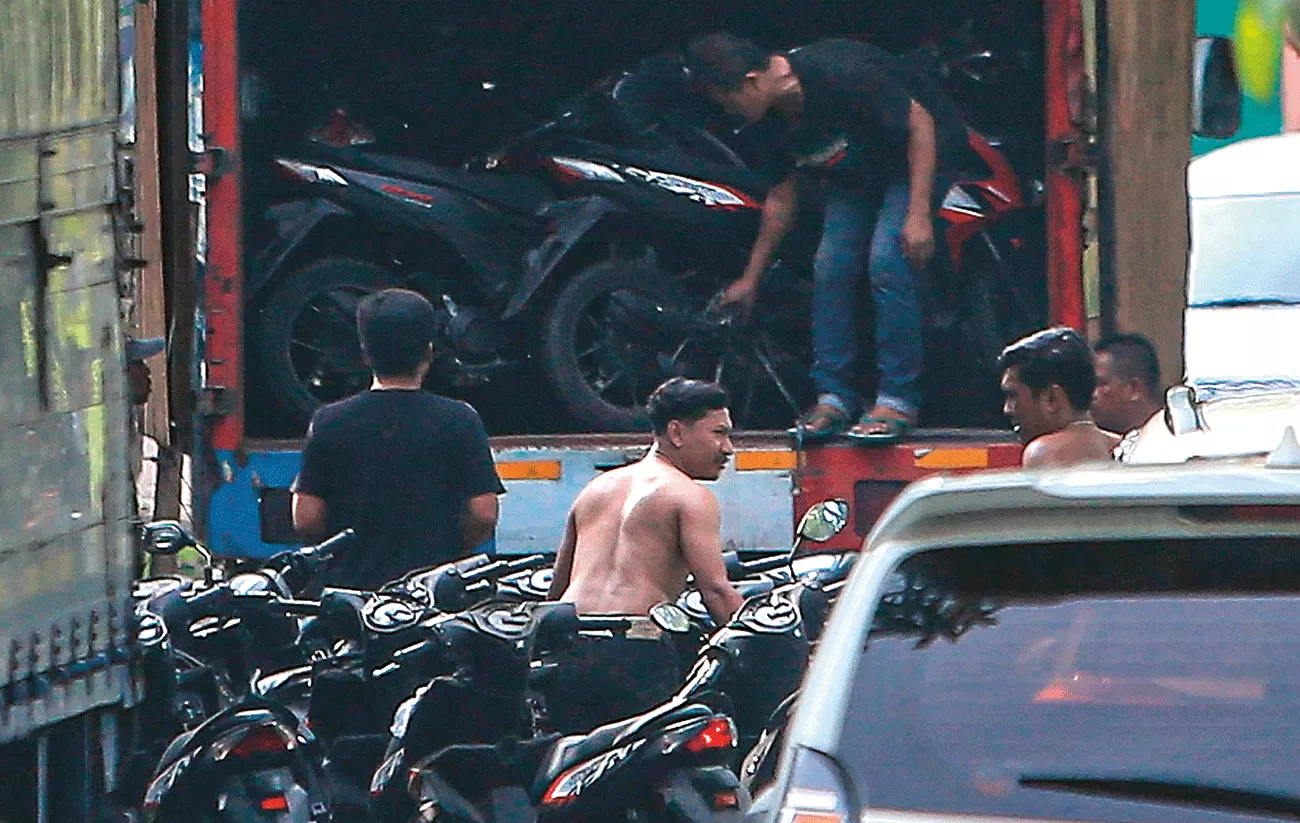 LACAK PENADAH: Petugas menaikkan kendaraan bermotor yang tersimpan di Gudbalkir Pusziad, Buduran, Sidoarjo, ke truk kontrainer, Sabtu (6/1). (TIM JAWA POS)/sumber: Jawapos.com
