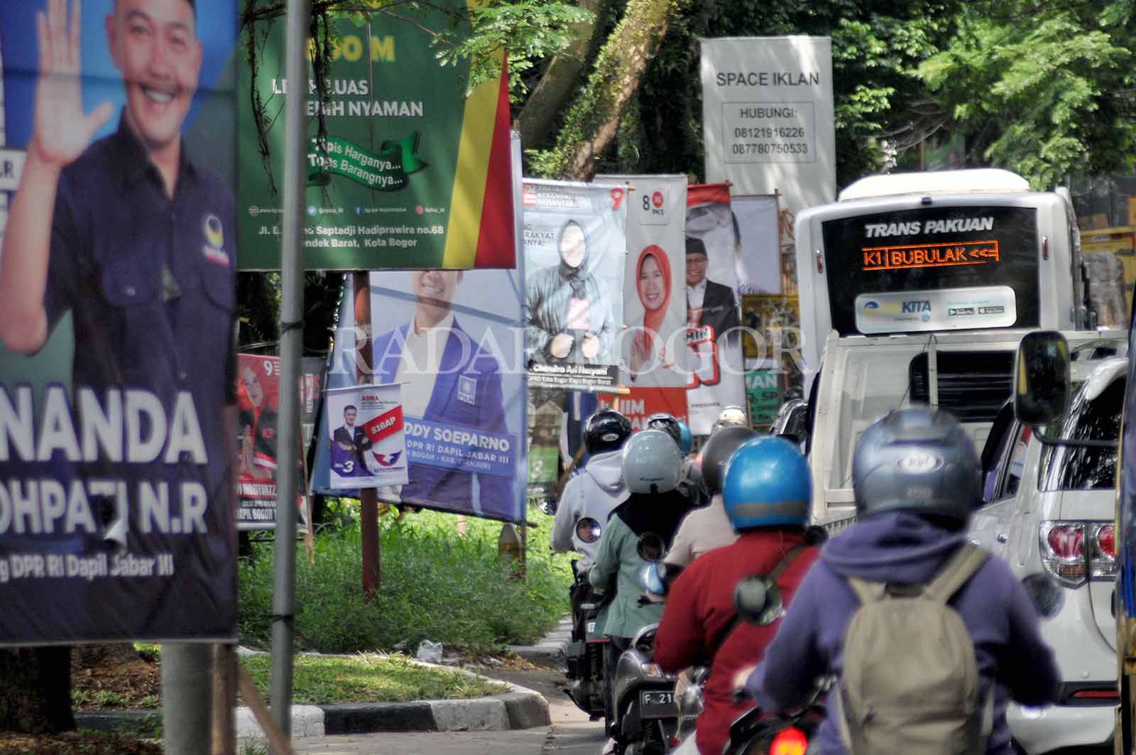 Pengendara melintas di jembatan Jalan KH. Abdulah Bin Nuh Kota Bogor, Jawa Barat yang di penuhi alat peraga kampanye serta bendera Partai. Senin (8/1/2024). Pesta Demokrasi lima tahunan tersebut kerap kali menghasilkan ribuan sampah visual yang terpasang