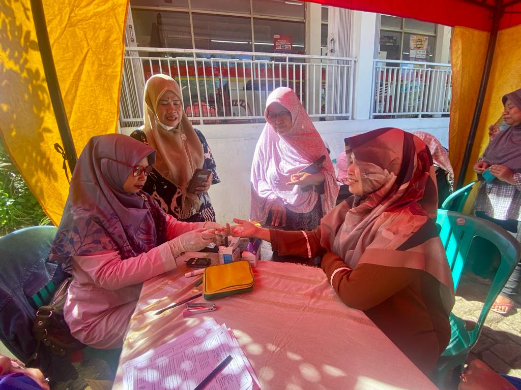 Puluhan warga Kelurahan Cibinong, Kecamatan Gunung Sindur, mengantre untuk ikuti pemeriksaan kesehatan gratis di depan toko Alfamart Alas Tua, Kamis (25/1/2024)﻿