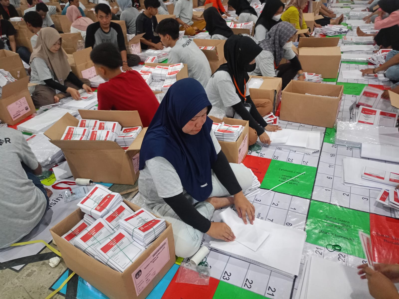 Siti ketika melakukan pelipatan kertas suara di gudang logistik milik KPU Kabupaten Bogor, tepatnya di wilayah Kecamatan Klapanunggal.