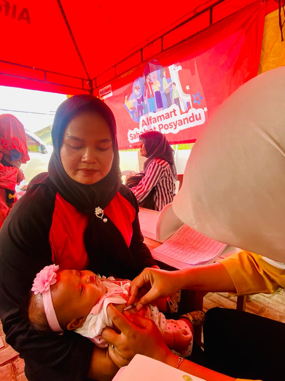 Warga Cipinang Bogor membawa anaknya imunisasi di Alfamart. IST