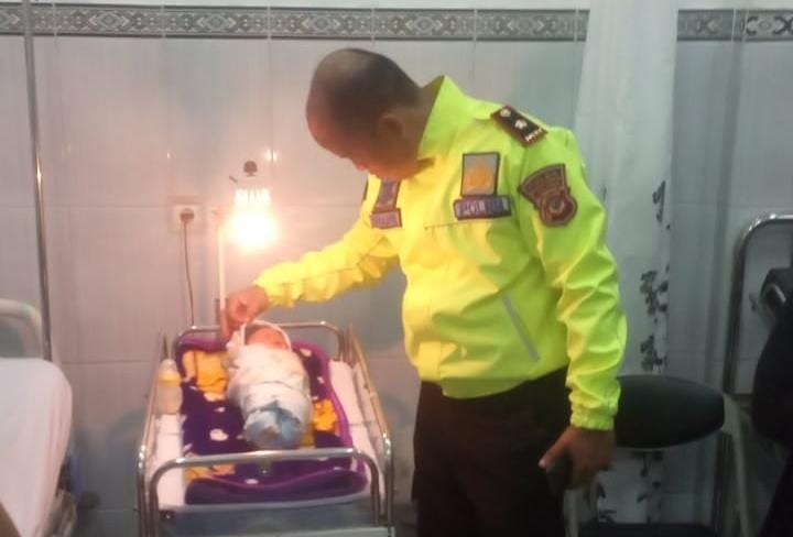 Polisi melihat kondisi bayi perempuan yang ditemukan di tumpukan sampah.