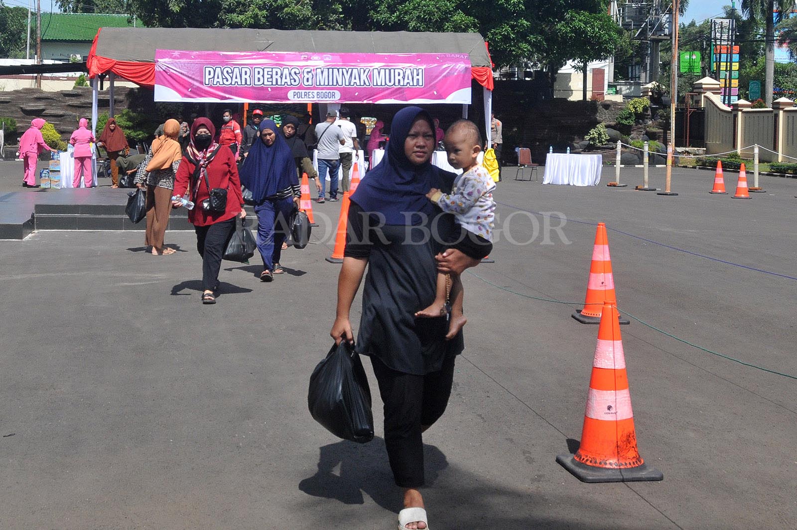 Warga usai membeli paket sembako operasi pasar murah di Polres Bogor, Kabupaten Bogor, Jawa Barat, Rabu (6/3/2024). Pasar murah beras dan minyak yang digelar atas kerjasama Polres Bogor dan Bulog tersebut bertujuan untuk mengendalikan harga sembako teruta