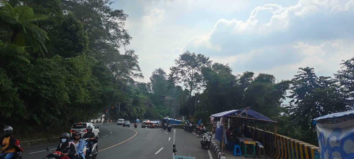 JEDA: Tampak para pemudik yang menggunakan motor memilih beristirahat di pinggir-pinggir Jalan Raya Puncak Bogor, dekat PKL.