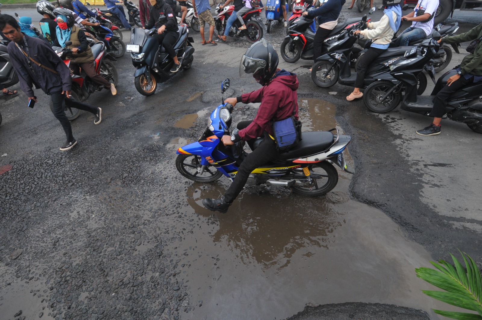 Pengendara melintas di Jalan Mayor Oking, Cibinong, Kabupaten Bogor yang berlubang, kondisi jalan tersebut hingga kini belum diperbaiki. Foto : Radar Bogor / Hendi Novian