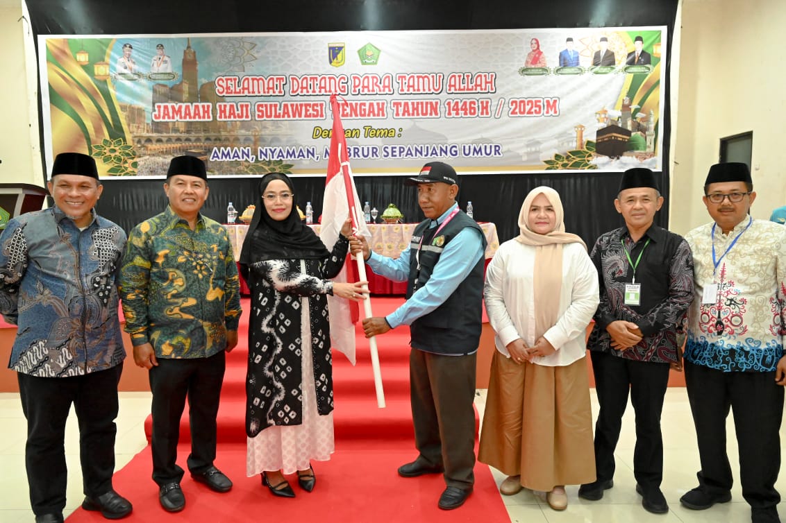 Sekdaprov Novalina secara simbolis menyerahkan bendera Merah Putih kepada perwakilan jemaah calon haji asal Sulawesi Tengah.