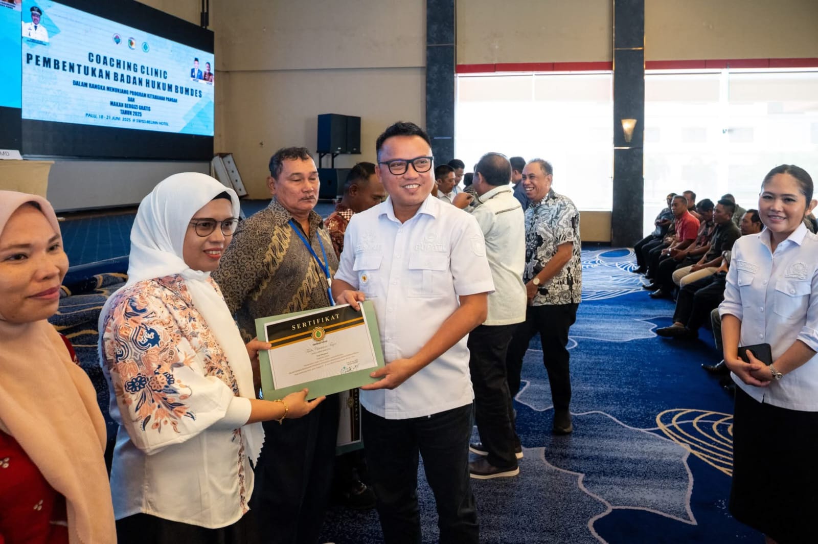 SERTIFIKAT : Bupati Morowali Utara Delis Julkarson Hehi menyerahkan sertifikat kepada peserta Coaching Clinic Pembentukan Badan Hukum Bumdes di Swiss-Belhotel Palu, Sabtu (21/6/2025).(FOTO : ISTIMEWA/