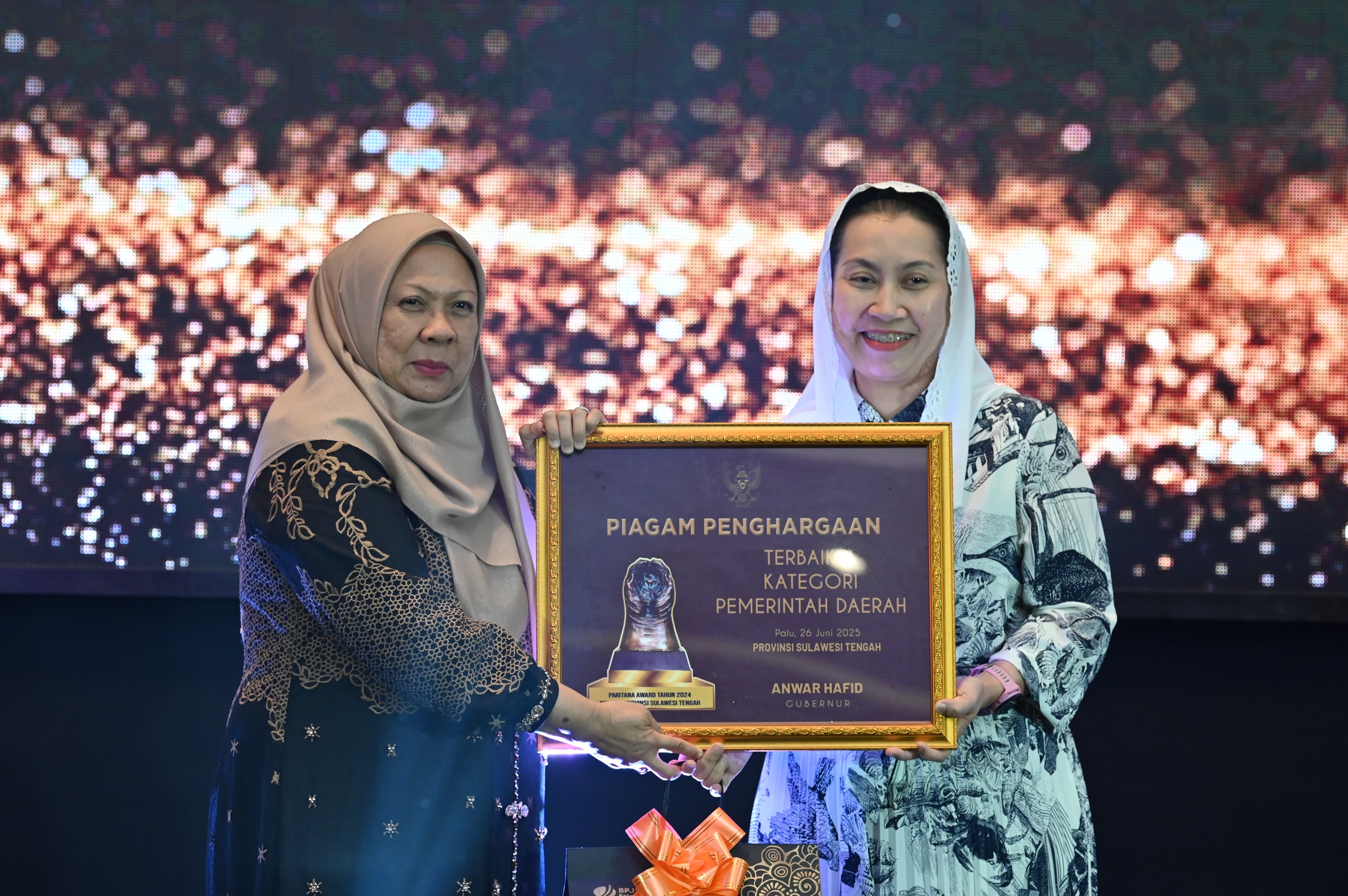 Wakil Gubernur Reny Lamadjido menyerahkan Paritrana Award 2025 kepada Wakil Wali Kota Palu Imelda Muhidin di Hotel Santika, Kamis (26/6/2025).