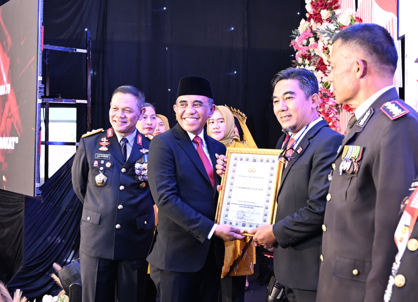 Gubernur Sulawesi Tengah Anwar Hafid menyerahkan piagam penghargaan kepada perwakilan penerima dalam rangka HUT ke-79 Bhayangkara di Gedung Pogombo, Palu.