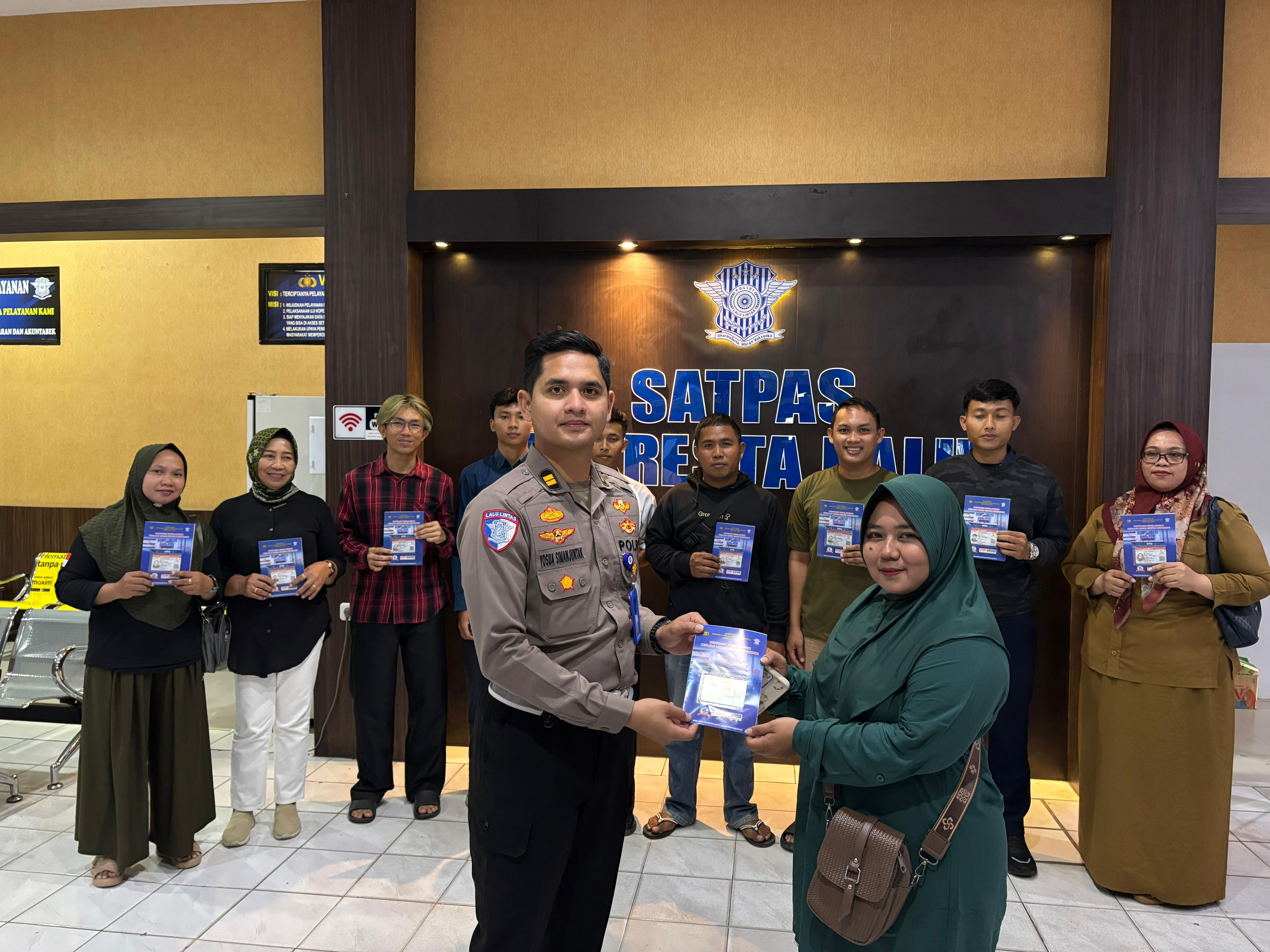 Kanit Regident Satlantas Polresta Palu, IPTU Yosua Martua, menyerahkan SIM secara simbolis kepada salah satu warga Palu yang lahir pada 1 Juli, dalam rangka peringatan Hari Bhayangkara ke-79.