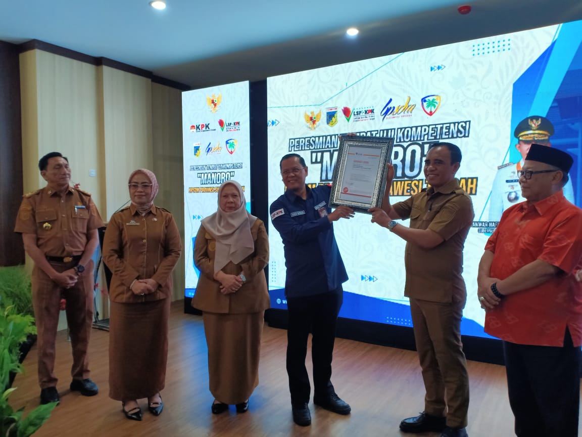 SERTIFIKAT : Deputi Pendidikan dan Peran Serta Masyarakat KPK, Wawan Wardian, menyerahkan sertifikat kepada Gubernur Sulteng Dr. H. Anwar Hafid. (FOTO : MUCHSIN SIRADJUDIN/RADAR PALU).