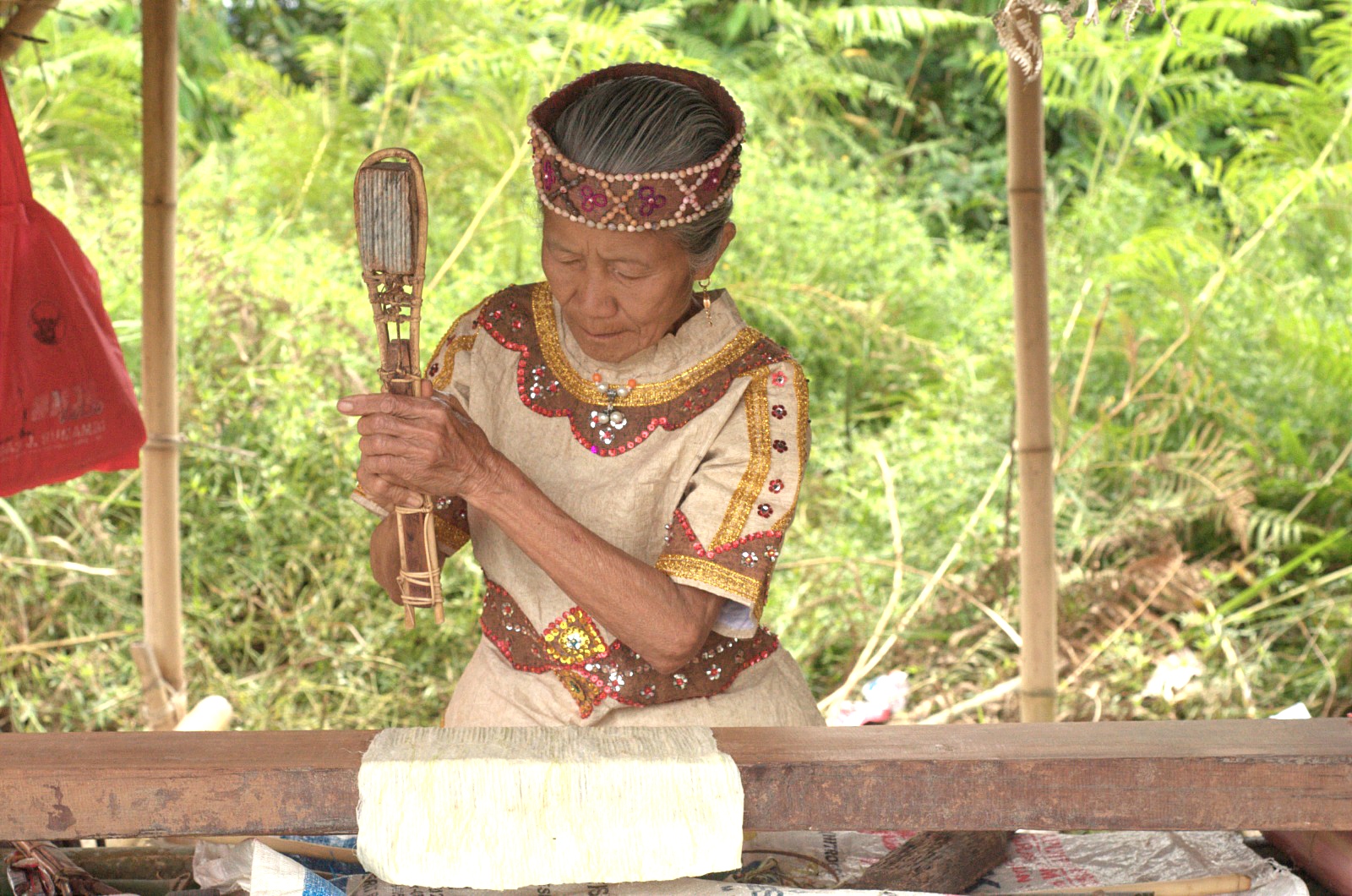 Titidi Tosada (78), pengrajin asal Desa Hanggira, Lembah Behoa, tengah menumbuk kulit kayu pohon Bea menggunakan alat tradisional batu ike.