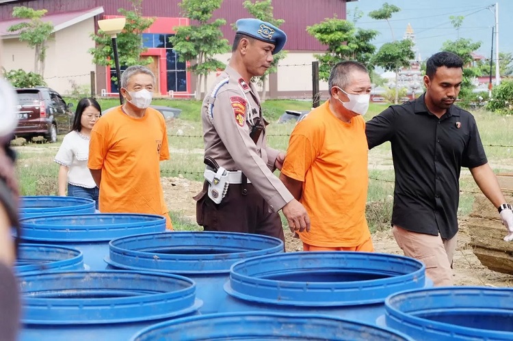 TERSANGKA: Dua WNA berbaju tahanan digiring aparat kepolisian Polda Sulteng saat menggelar konfrensi pers.