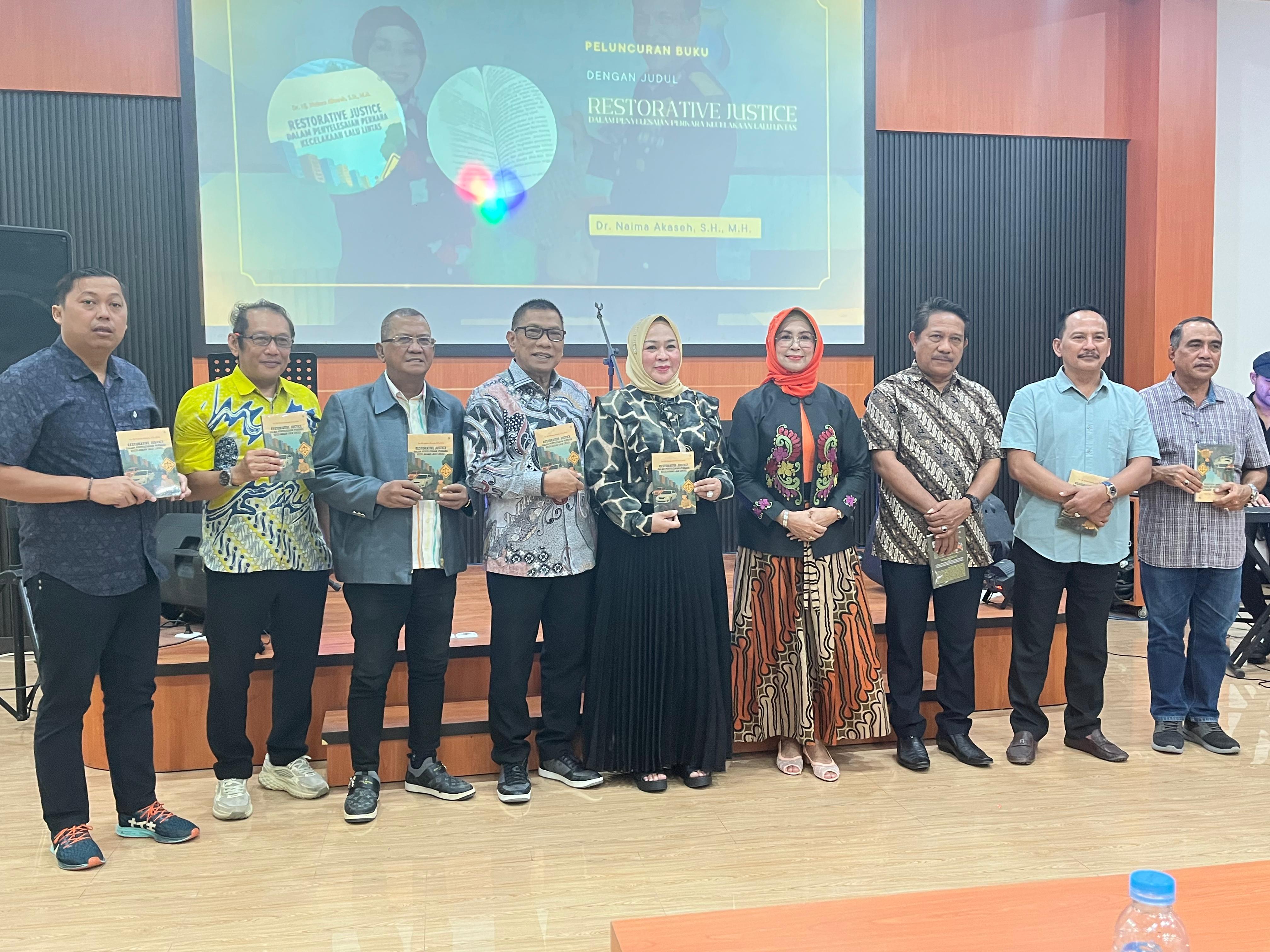 AKBP (Purn) Naima Akaseh, secara simbolis menyerahkan buku karyanya kepada para tamu undangan.