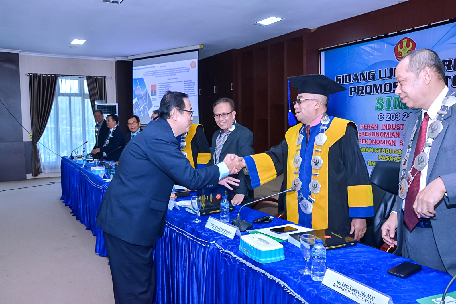LULUS : Tampak Dewan penguji memberikan ucapan selamat kepada Dr. Simon Antolis, usai dinyatakan lulus di FE Untad.(FOTO : ISTIMEWA/RADAR PALU).