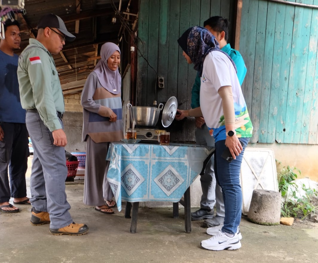 Salah seorang pemilik warung saat menggunakan gas methan hasil dari biodigester untuk keperluan memanaskan air.